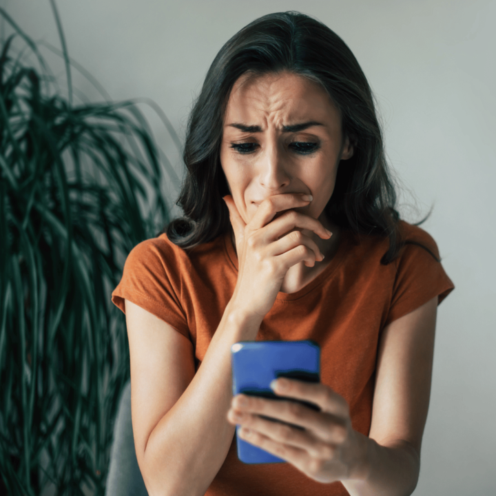 Ledsen kvinna som tittar på mobilen