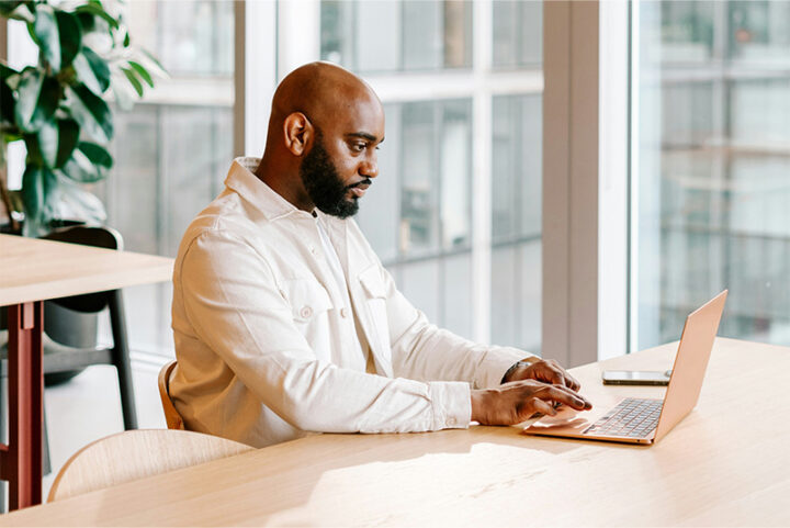 Man sitter vid sin laptop