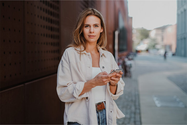Porträtt på kvinna som håller i sin mobil