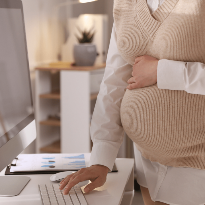 Gravid kvinna som jobbar framför datorn